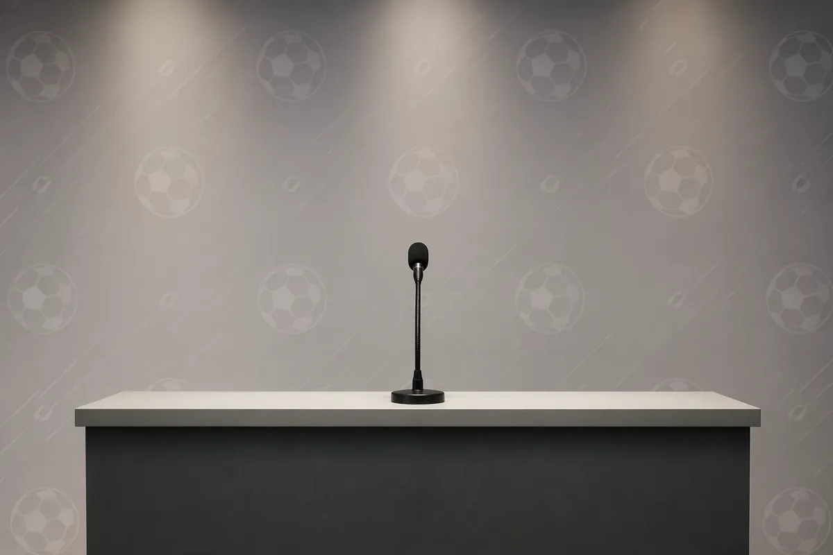 Professional football press conference scene, empty podium with a single microphone, neutr